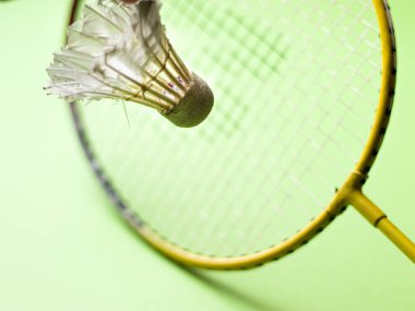 Badminton raketi ve beyaz tüylü Shuttlecock yeşil arkaplan stoğu görüntüsü izole. 