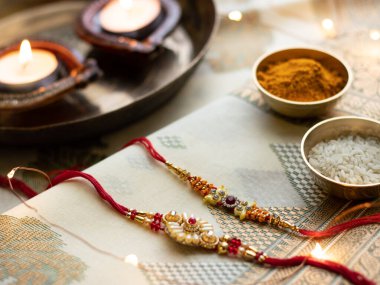 Raksha Bandhan, ahşap desenli arka planda zarif Rakhi ve pirinç taneleri ile donatılmış..