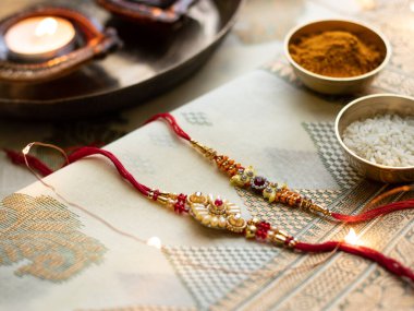 Raksha Bandhan, ahşap desenli arka planda zarif Rakhi ve pirinç taneleri ile donatılmış..