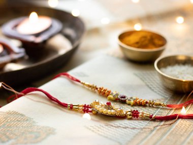 Raksha Bandhan, ahşap desenli arka planda zarif Rakhi ve pirinç taneleri ile donatılmış..