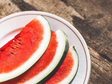 Beyaz tabakta dilimlenmiş karpuz kaşık ve çatal desenli beyaz arka planlı fotoğraf..