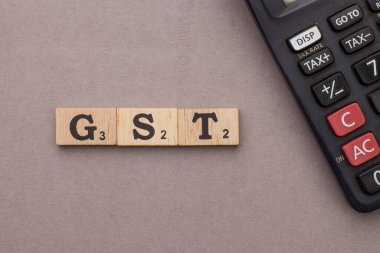 Assam, Hindistan - 30 Mart 2021: Tahta küplerin üzerine kelime GST yazıldı.