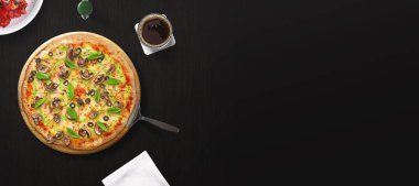 Koyu arka planda pizza. Lezzetli geleneksel İtalyan pizzasının en iyi manzarası. Reklam için iyi bir kullanım.