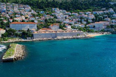 Adriyatik Denizi 'nin güzel mavi suları boyunca eski kasabanın yakınındaki yamaçta yeni evler gelişti.