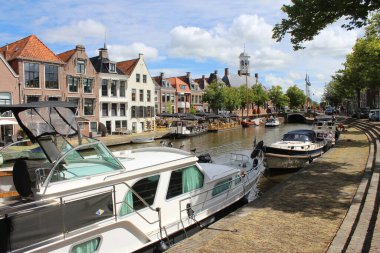 DOKKKUM, NETHERLANDS, 22 HAZİRAN 2020: Klein Diep kanalının ve Dokkum 'daki Vleesmarkt' ın deniz kenarındaki binalarının görüntüsü. Tarihi kasaba merkezi Friesland 'da popüler bir turizm merkezidir..