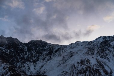 Güneşin doğuşundaki güzel kış dağları manzarası. Yoğun kar sisli dağları kapladı. Georgia, Kazbegi.