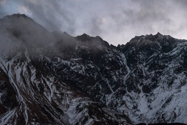 Güneşin doğuşundaki güzel kış dağları manzarası. Yoğun kar sisli dağları kapladı. Georgia, Kazbegi.