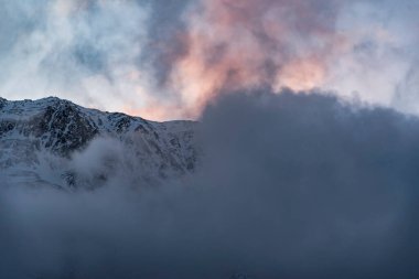 Güneşin doğuşundaki güzel kış dağları manzarası. Yoğun kar sisli dağları kapladı. Georgia, Kazbegi.