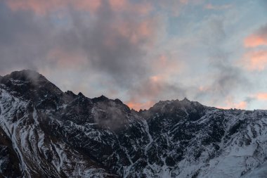 Güneşin doğuşundaki güzel kış dağları manzarası. Yoğun kar sisli dağları kapladı. Georgia, Kazbegi.