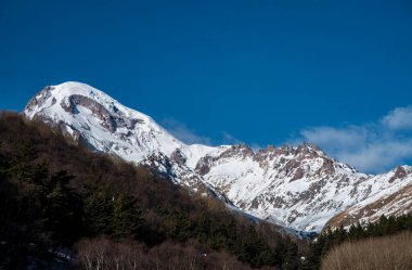 Yüksek karla kaplı dağ Kazbek. Kış dağları manzarası. Georgia, Kazbegi.