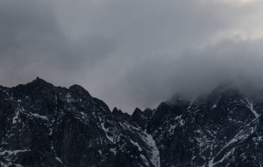 Güneşin doğuşundaki güzel kış dağları manzarası. Yoğun kar sisli dağları kapladı. Georgia, Kazbegi.