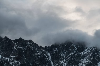 Güneşin doğuşundaki güzel kış dağları manzarası. Yoğun kar sisli dağları kapladı. Georgia, Kazbegi.