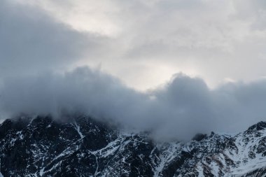 Güneşin doğuşundaki güzel kış dağları manzarası. Yoğun kar sisli dağları kapladı. Georgia, Kazbegi.