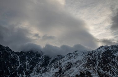 Güneşin doğuşundaki güzel kış dağları manzarası. Yoğun kar sisli dağları kapladı. Georgia, Kazbegi.