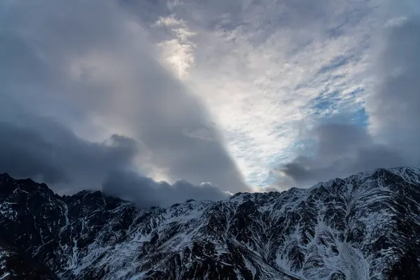 Güneşin doğuşundaki güzel kış dağları manzarası. Yoğun kar sisli dağları kapladı. Georgia, Kazbegi.