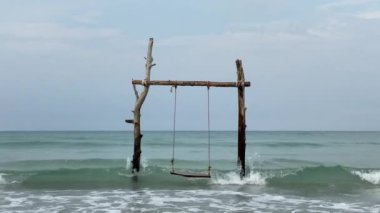 Plaj sallanıyor ve okyanus dalgalarını izliyor. Okyanus sahilinde kaygısız bir yaz anı.