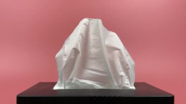 Slow motion, a person's hand pull out a piece of tissue from tissue paper box isolated on pink background.