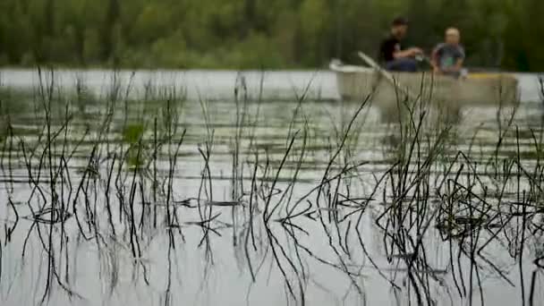 Two fishermen are fishing on a boat in the forest on the lake — Αρχείο Βίντεο