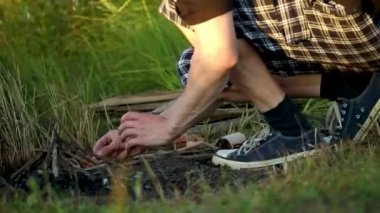 Rüzgarlı havada ateş yakan bir adam.,