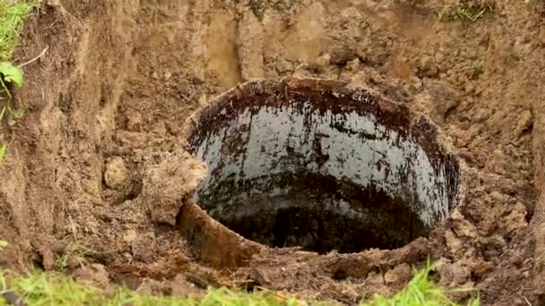 Muž na zahradním pozemku rozebírá starou studnu, — Stock video