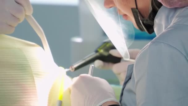 Dokter gigi wanita profesional dengan asisten melakukan operasi di klinik gigi — Stok Video