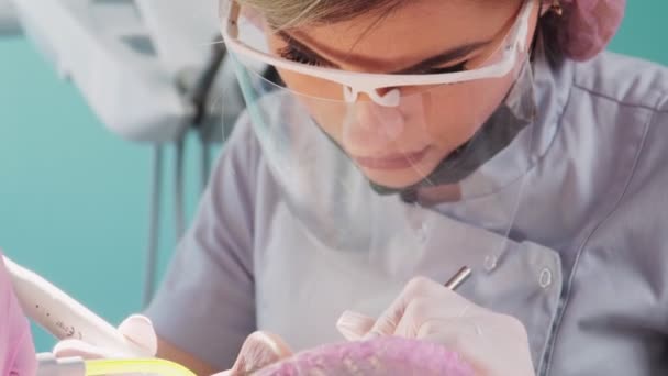 Professionell kvinnlig tandläkare med assistent utföra en operation i tandvårdskliniken — Stockvideo