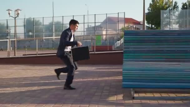 Biznesmen biegnie szybko z walizką biznesową w rękach Pędząc do pracy — Wideo stockowe
