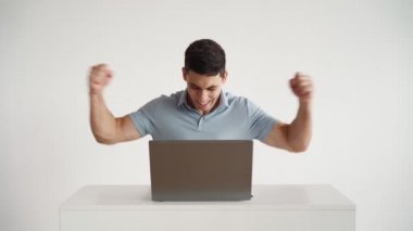 Mutlu ofis çalışanı dizüstü bilgisayarda çalışır ve başarılı anlaşmada neşeli olur.