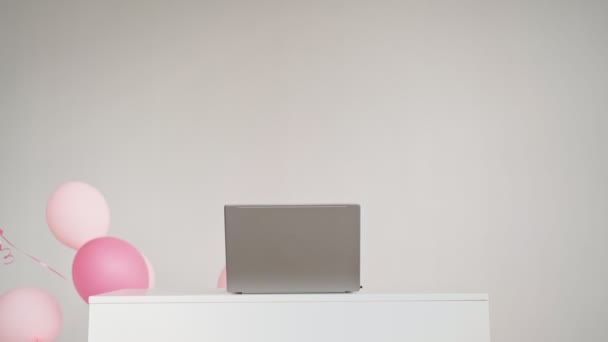 Desktop z laptopem, za którym świąteczne kulki pojawiają się na białym tle — Wideo stockowe