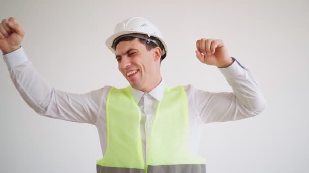 Glücklicher Bauarbeiter in weißem Helm und Hemd freut sich über Bauende — Stockvideo