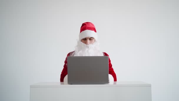 Santa Claus typing text on laptop keyboard on white background. Christmas online — Stock Video