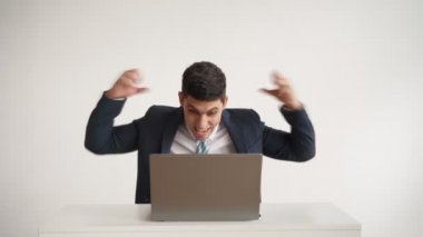 Mutlu ofis çalışanı dizüstü bilgisayarda çalışır ve başarılı anlaşmada neşeli olur.