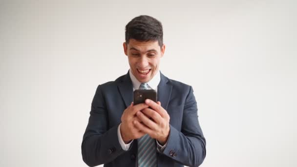 Feliz trabajador de oficina masculino en ropa formal utiliza teléfono móvil se regocija en la victoria — Vídeos de Stock