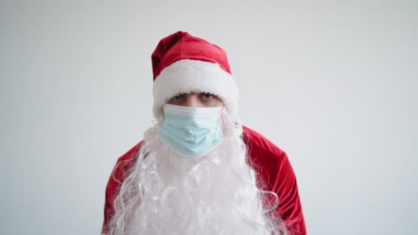 Santa Claus en máscara médica se ve cámara. Cuarentena de Navidad y coronavirus — Vídeos de Stock