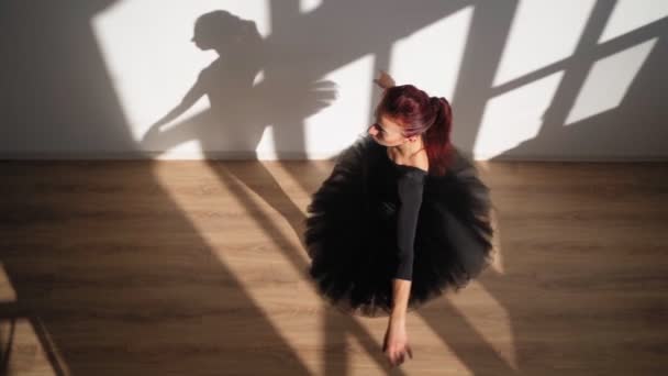 Ballerina in Schwarz Tutu tanzt anmutig gegen weiße Wand im gleißenden Sonnenlicht — Stockvideo