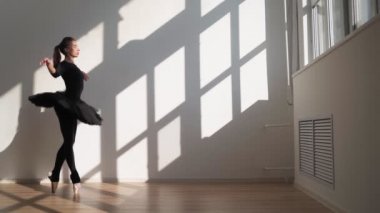 Siyah Tutu 'lu Balerin Parlak Güneş Işığıyla Beyaz Duvar' a Karşı Zarifçe Dans Ediyor