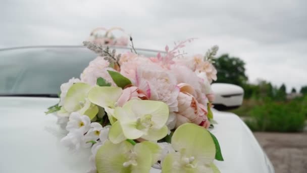 Een close-up. Auto is versierd met bruiloft decoraties en bloemen. Langzame beweging — Stockvideo