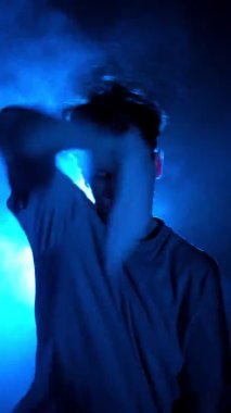 Siluet, erkek sokak dansçısı dumanlı odada dans ediyor.