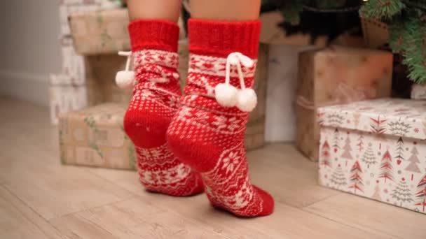 Female Legs in Red New Years Socks on Tiptoe. Woman Decorates a Christmas Tree — Stock Video