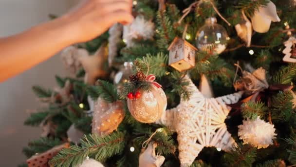 Mulher decora árvore de Natal com bolas festivas. Luzes quentes guirlandas Flicker — Vídeo de Stock