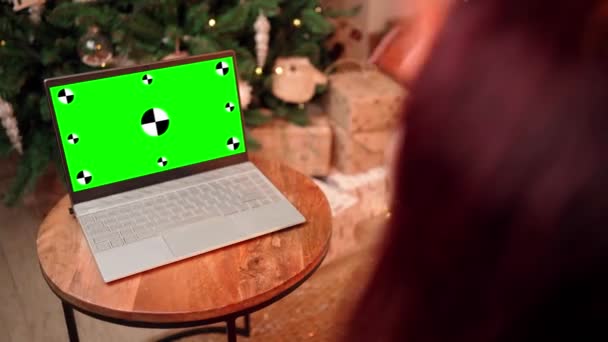 Femeia de Crăciun comunică prin apel video folosind laptopul cu ecran verde. — Videoclip de stoc