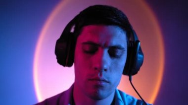 Portre, adam neon ışıkta kulaklıkla müzik dinleyerek rahatlıyor