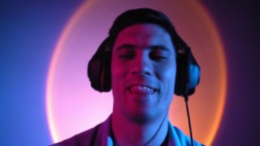 Portre, adam neon ışıkta kulaklıkla müzik dinleyerek rahatlıyor