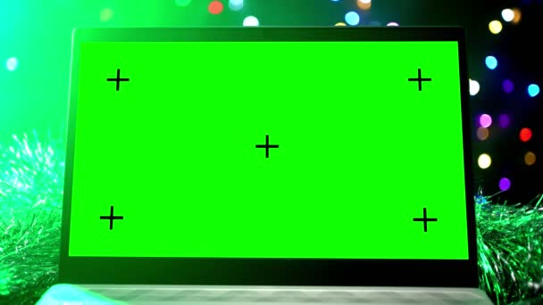 Ноутбук с зеленым экраном фон светящиеся гирлянды и новогодние украшения — стоковое видео