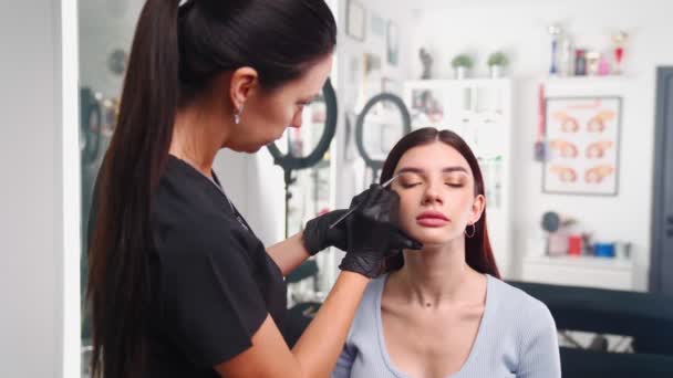Maquiagem permanente mestre prepara cliente mulher para sobrancelha microblading procedimento — Vídeo de Stock