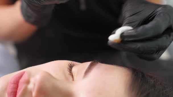 Maestro hace permanente el procedimiento de maquillaje de cejas a la mujer en el salón de belleza. — Vídeos de Stock