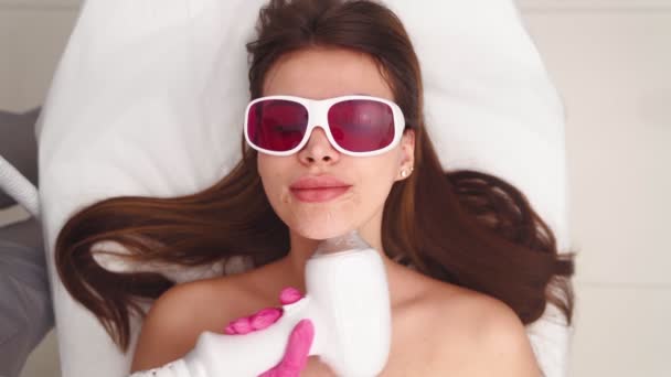 Cosmetólogo hace que la depilación facial láser hermosa mujer en el salón de belleza — Vídeo de stock