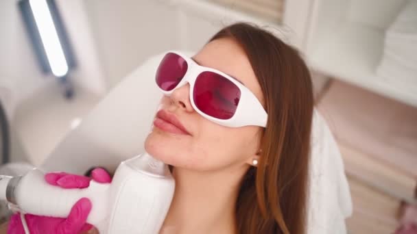Cosmetologist makes laser facial hair removal beautiful woman in beauty salon — 图库视频影像