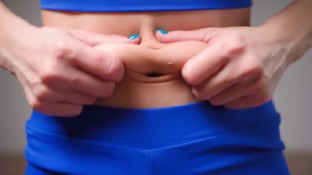 Wanita atletik menunjukkan lemak perut. Konsep slimming — Stok Video