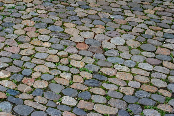 ヨーロッパの街の歩道や中庭にあるヴィンテージの石畳の歩道の表面のビューを閉じます — ストック写真